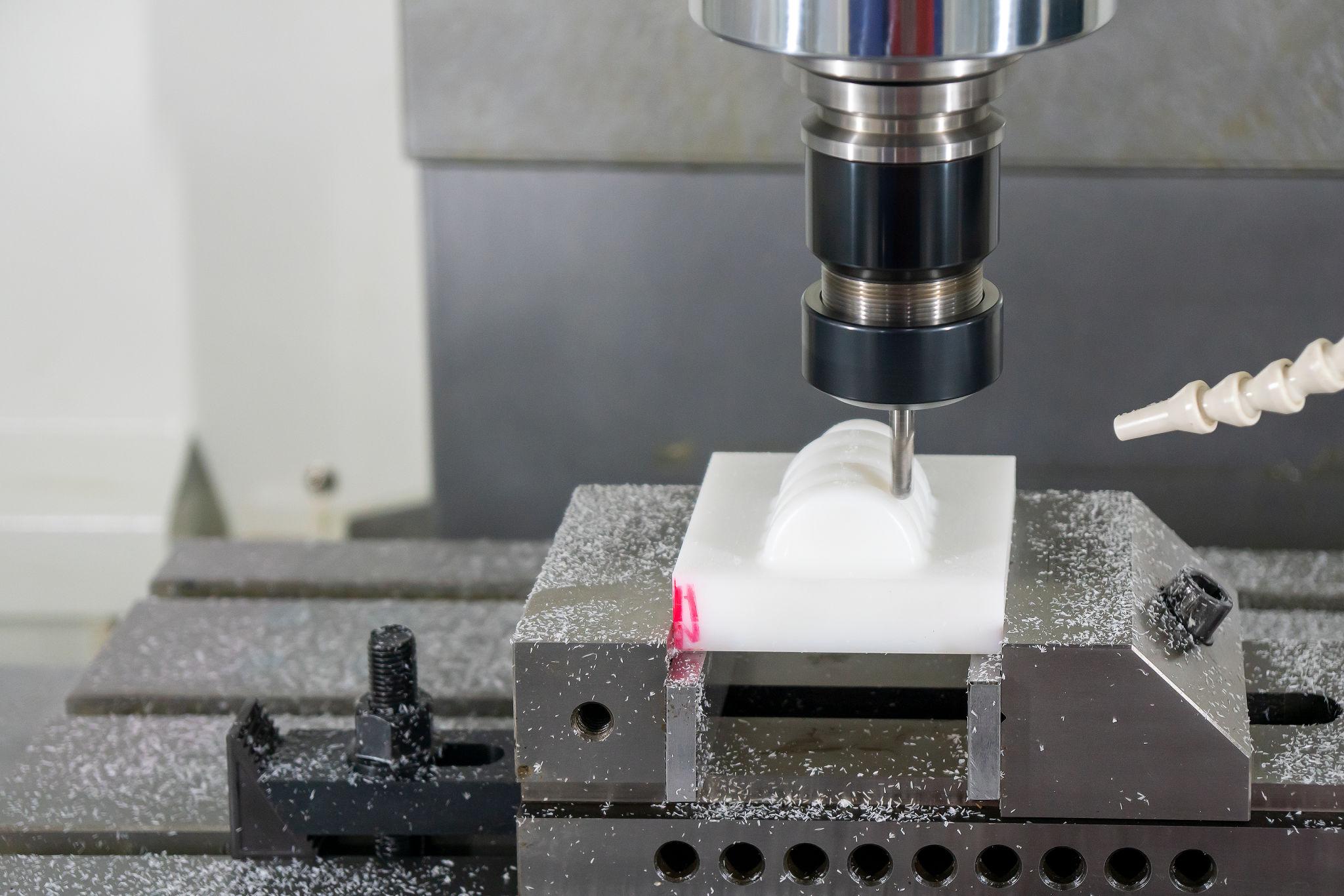 The CNC milling machine cutting the engineering plastic parts by solid endmill tool. The hi-precision non-metal part manufacturing concept by machining center.